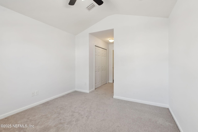 carpeted empty room featuring visible vents, vaulted ceiling, baseboards, and ceiling fan