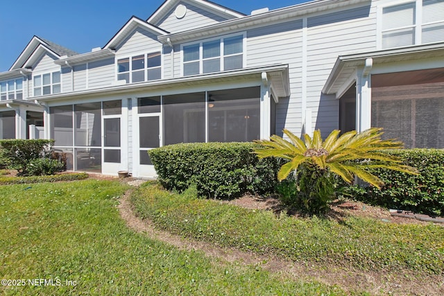 view of home's exterior featuring a sunroom and a yard