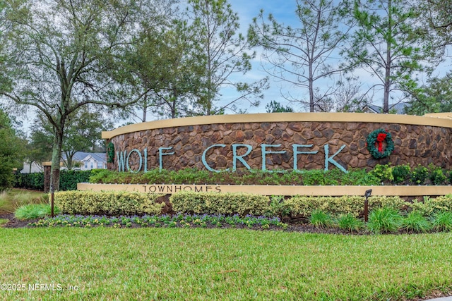 community / neighborhood sign with a yard