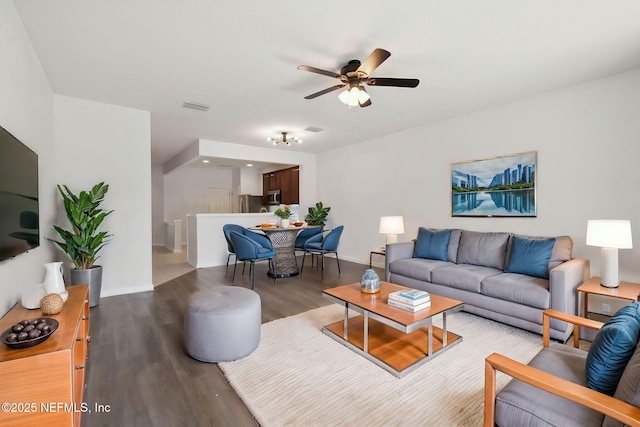 living area with a ceiling fan, baseboards, visible vents, and wood finished floors