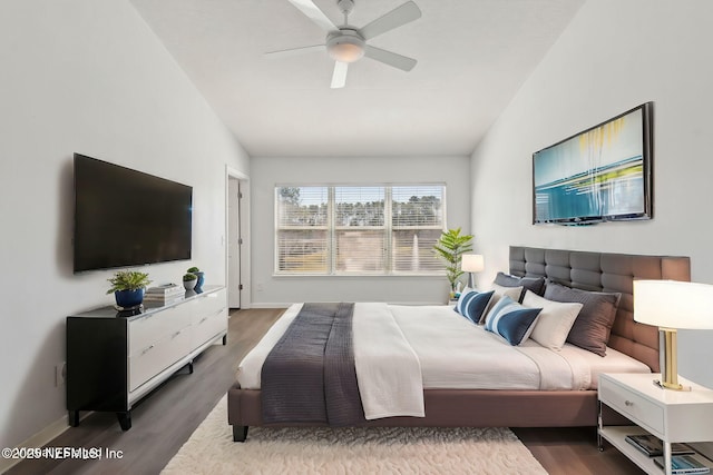 bedroom with lofted ceiling, ceiling fan, wood finished floors, and baseboards