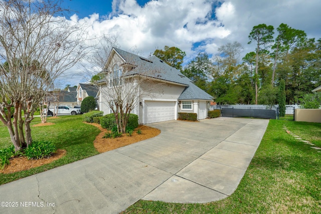 view of side of home with a garage, a lawn, driveway, and fence