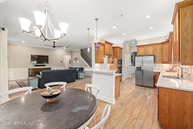 dining room featuring crown molding, light wood-type flooring, stairs, recessed lighting, and wainscoting