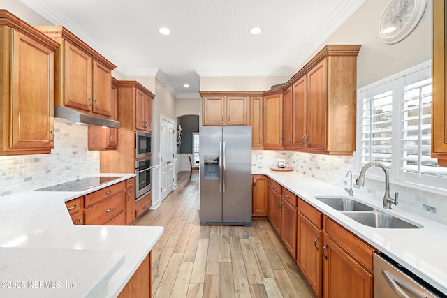 kitchen featuring a sink, brown cabinets, appliances with stainless steel finishes, and under cabinet range hood