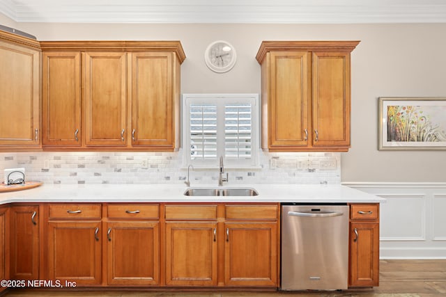 kitchen featuring a sink, stainless steel dishwasher, crown molding, and light countertops