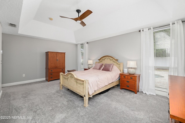 bedroom with visible vents, baseboards, a raised ceiling, and carpet