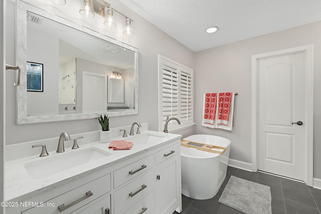 full bathroom featuring a sink, a freestanding bath, and tile patterned floors