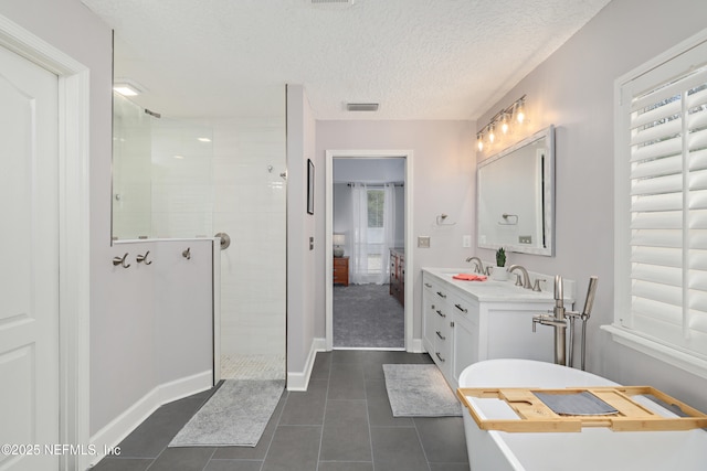 ensuite bathroom featuring tile patterned flooring, visible vents, walk in shower, vanity, and a textured ceiling