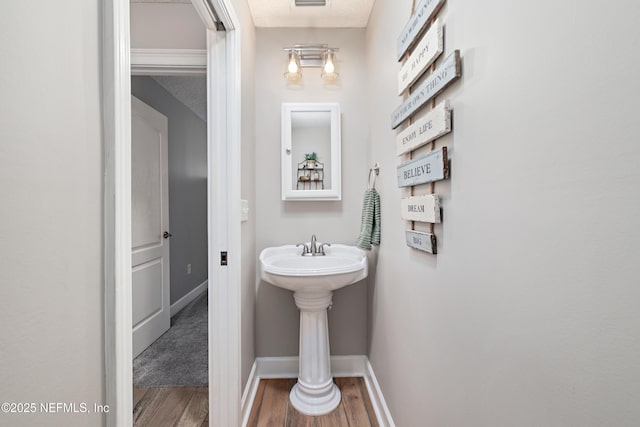 bathroom with visible vents, baseboards, and wood finished floors