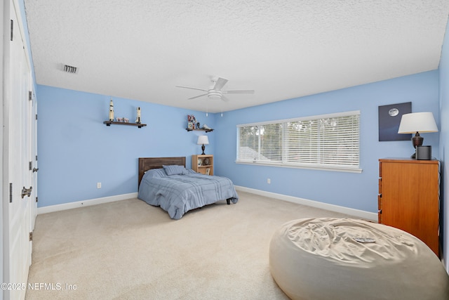 bedroom with visible vents, carpet floors, a textured ceiling, and baseboards