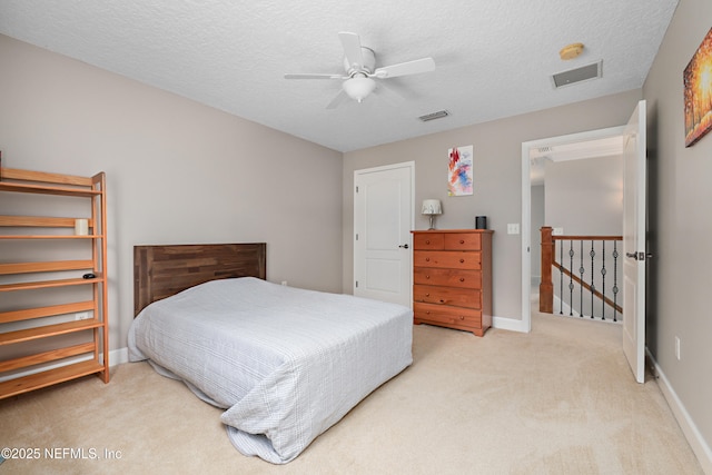 carpeted bedroom with visible vents, baseboards, and a textured ceiling