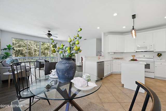 kitchen with light tile patterned floors, recessed lighting, white appliances, white cabinets, and light countertops