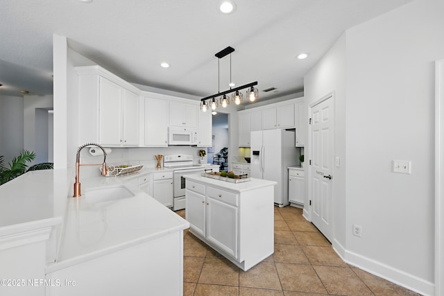 kitchen featuring light tile patterned floors, white appliances, a sink, and white cabinets