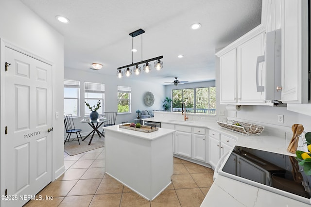 kitchen featuring plenty of natural light, light countertops, a sink, and light tile patterned flooring