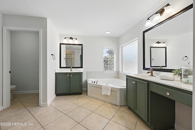 bathroom featuring tile patterned flooring, a garden tub, a sink, and toilet