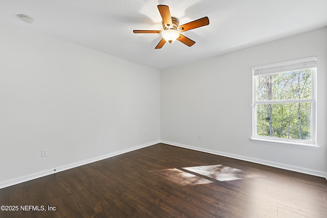 unfurnished room featuring ceiling fan, baseboards, and dark wood finished floors