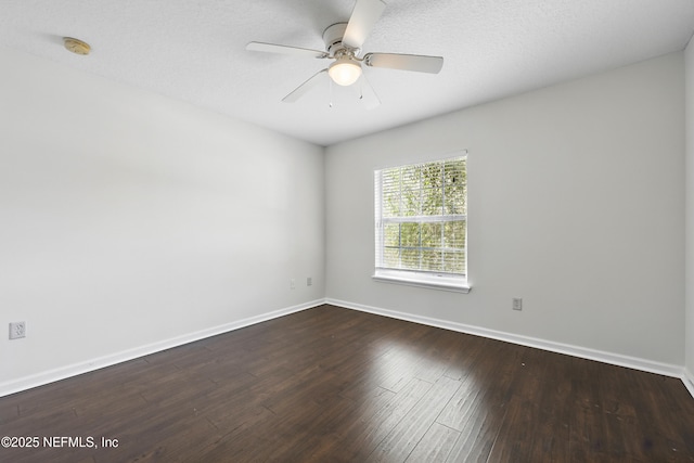 spare room with dark wood-type flooring, baseboards, and a ceiling fan