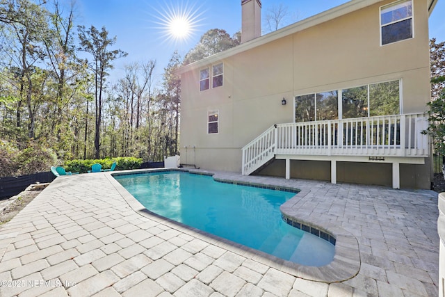 pool with a patio, a deck, and stairs