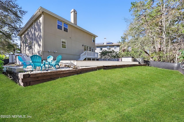 rear view of property with a lawn, a chimney, and a patio