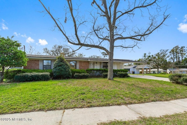 view of front of house with driveway, a front lawn, an attached carport, and brick siding