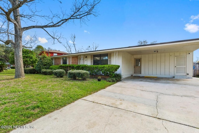 ranch-style house with driveway, a carport, a front yard, and brick siding