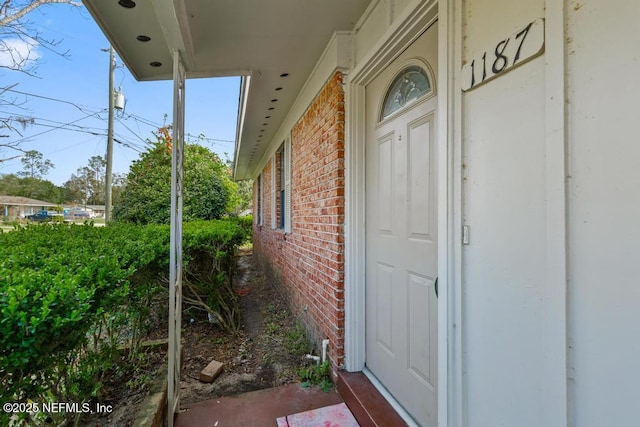 doorway to property featuring brick siding