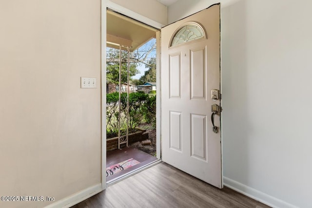 foyer featuring baseboards and wood finished floors