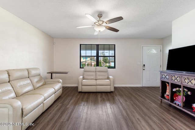 living room featuring a textured ceiling, wood finished floors, a ceiling fan, and baseboards