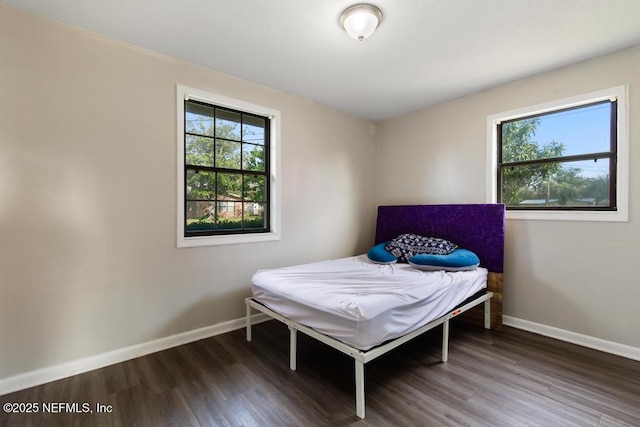 bedroom with baseboards and wood finished floors