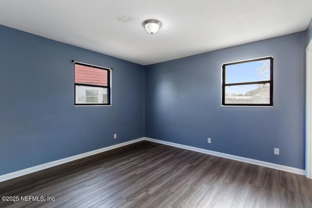 empty room with baseboards and wood finished floors