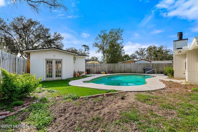 view of pool with a fenced in pool, french doors, and a fenced backyard