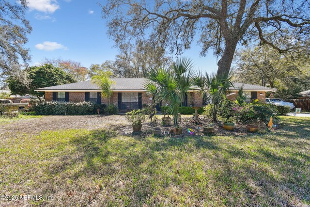 ranch-style home featuring brick siding and a front yard