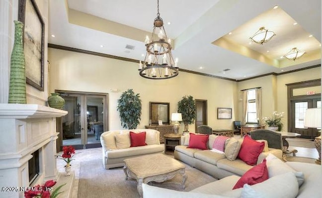 living area featuring french doors, a tray ceiling, and crown molding