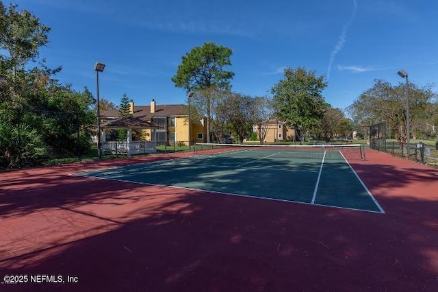 view of tennis court featuring fence