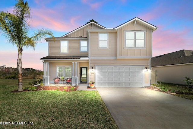 traditional-style home with board and batten siding, an attached garage, driveway, and a front lawn