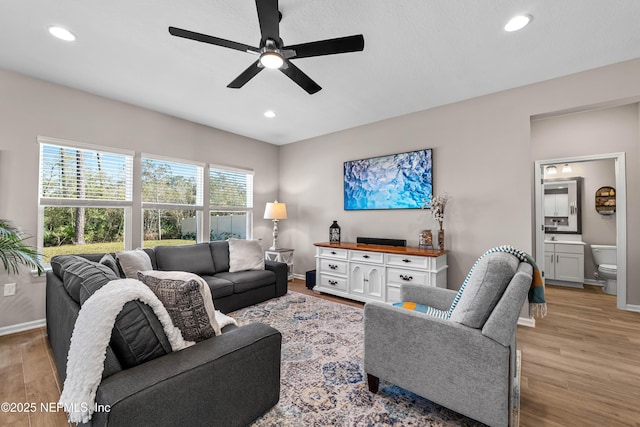 living area featuring baseboards, recessed lighting, and light wood-style floors