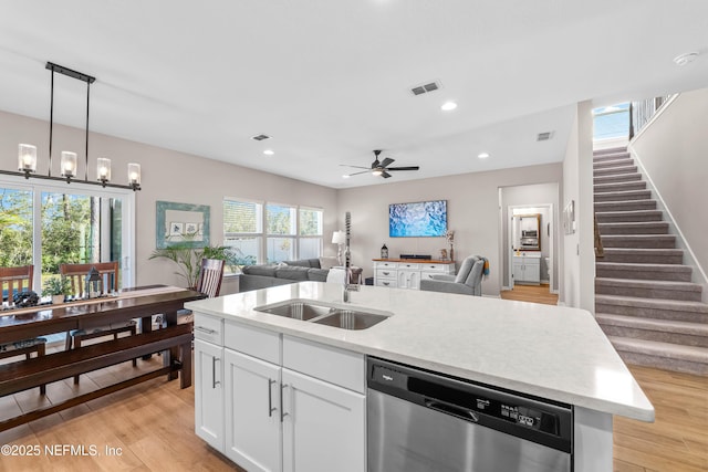 kitchen featuring a sink, visible vents, open floor plan, dishwasher, and light wood finished floors