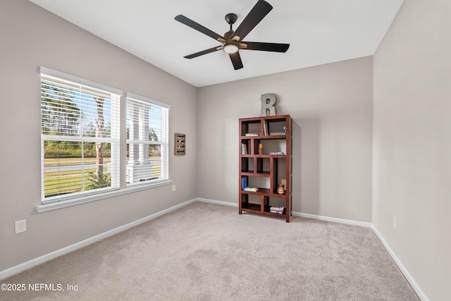 spare room with carpet, baseboards, and a ceiling fan