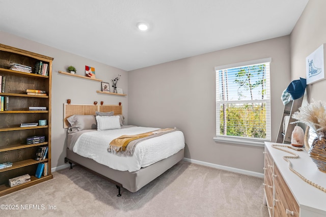 bedroom with baseboards and light colored carpet