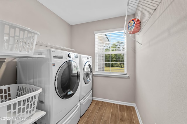 washroom featuring baseboards, laundry area, wood tiled floor, and washer and dryer