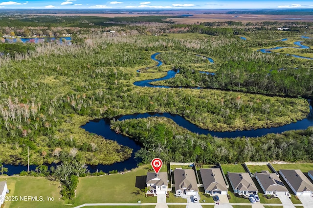 birds eye view of property featuring a water view and a wooded view