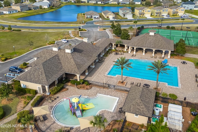 community pool featuring a residential view, a water view, fence, a patio area, and a water play area