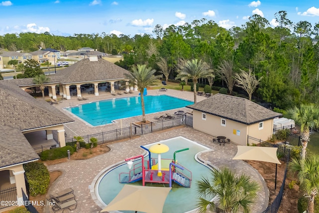 community pool with a gazebo, a patio area, a water play area, and fence