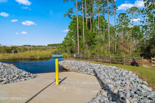 exterior space featuring a water view and fence