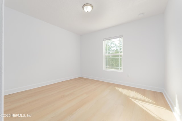 unfurnished room featuring wood finished floors and baseboards