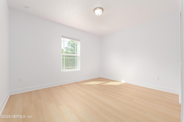 unfurnished room featuring baseboards and wood finished floors