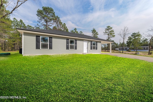 single story home featuring driveway, a front lawn, and a carport