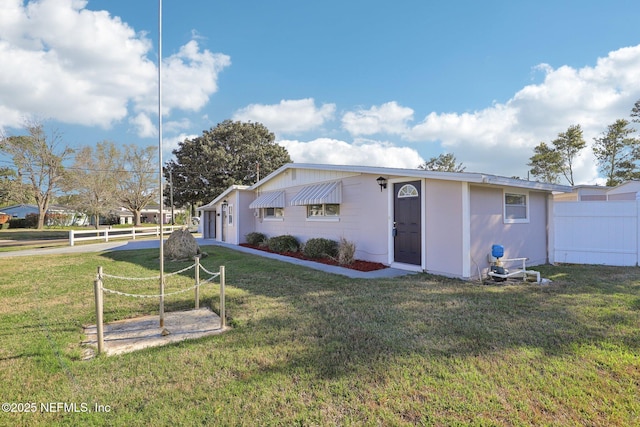 exterior space featuring a garage, fence, and a lawn