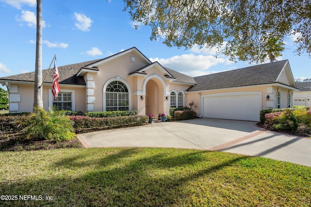 view of front of house with stucco siding, driveway, a front yard, and a garage