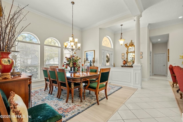 dining area with crown molding, decorative columns, light tile patterned flooring, and a wealth of natural light